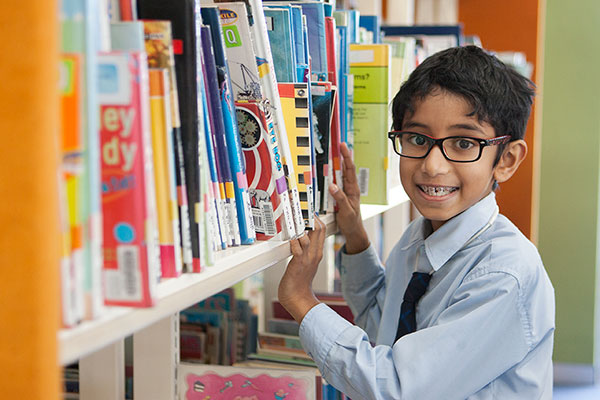 student looking through books in the school library