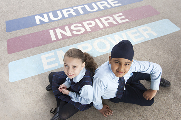 students sitting on school carpet with text Nurture, Inspire and Empower
